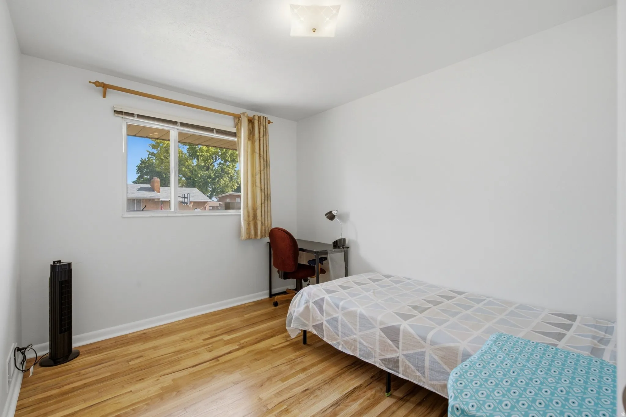 Interior room featuring wood-finish flooring, white painted walls, and a ceiling-mounted light fixture