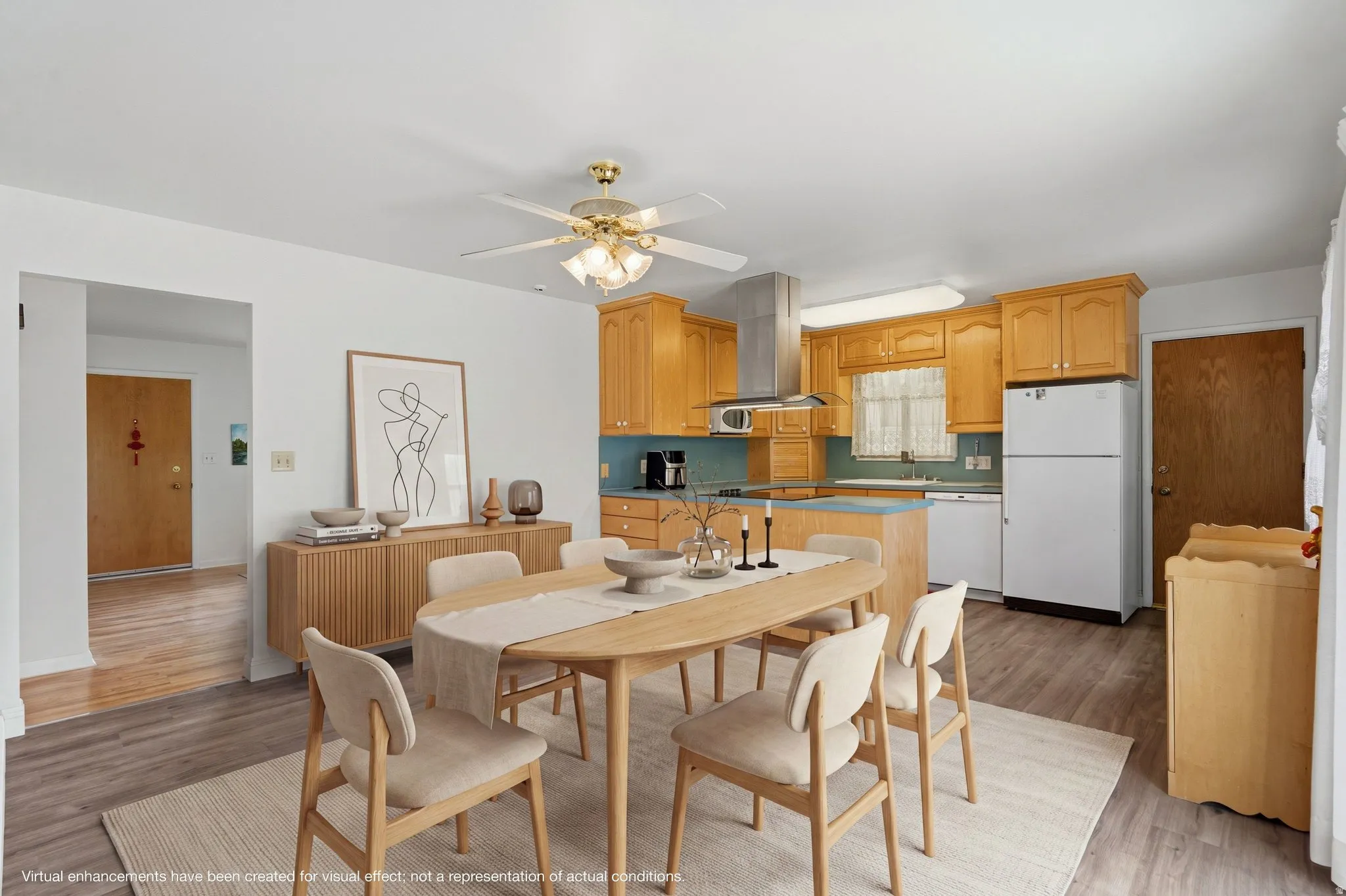 Open-concept kitchen and dining area featuring wood-finish flooring, warm-toned cabinetry, light blue backsplash, and a contemporary ceiling fan