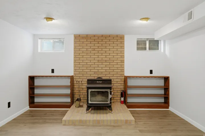 Brick-clad fireplace with a wood-burning stove and a raised hearth