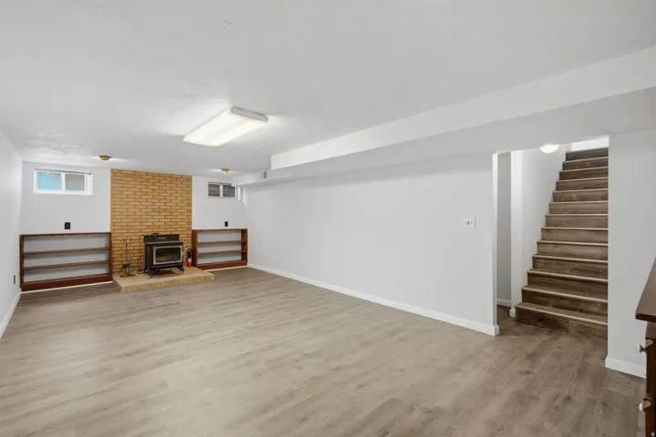 Spacious lower-level room featuring light wood-finish flooring and a white ceiling