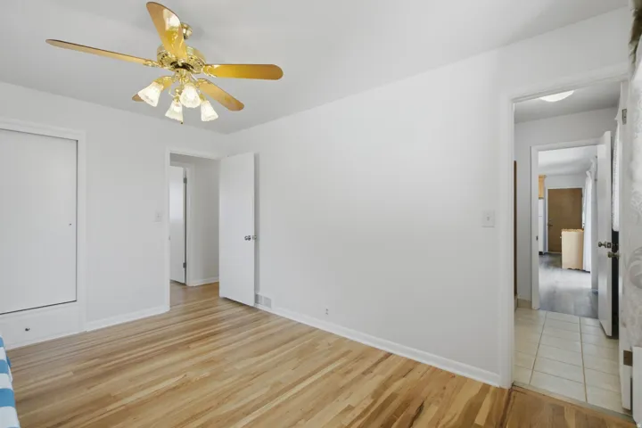 Hardwood flooring throughout this bright interior space, featuring a ceiling fan with integrated lighting