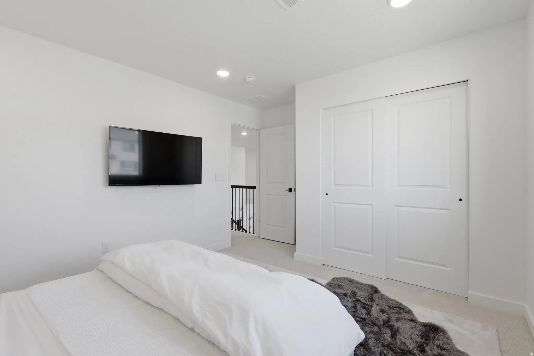 Bedroom featuring white walls, recessed lighting, and light-toned carpeting