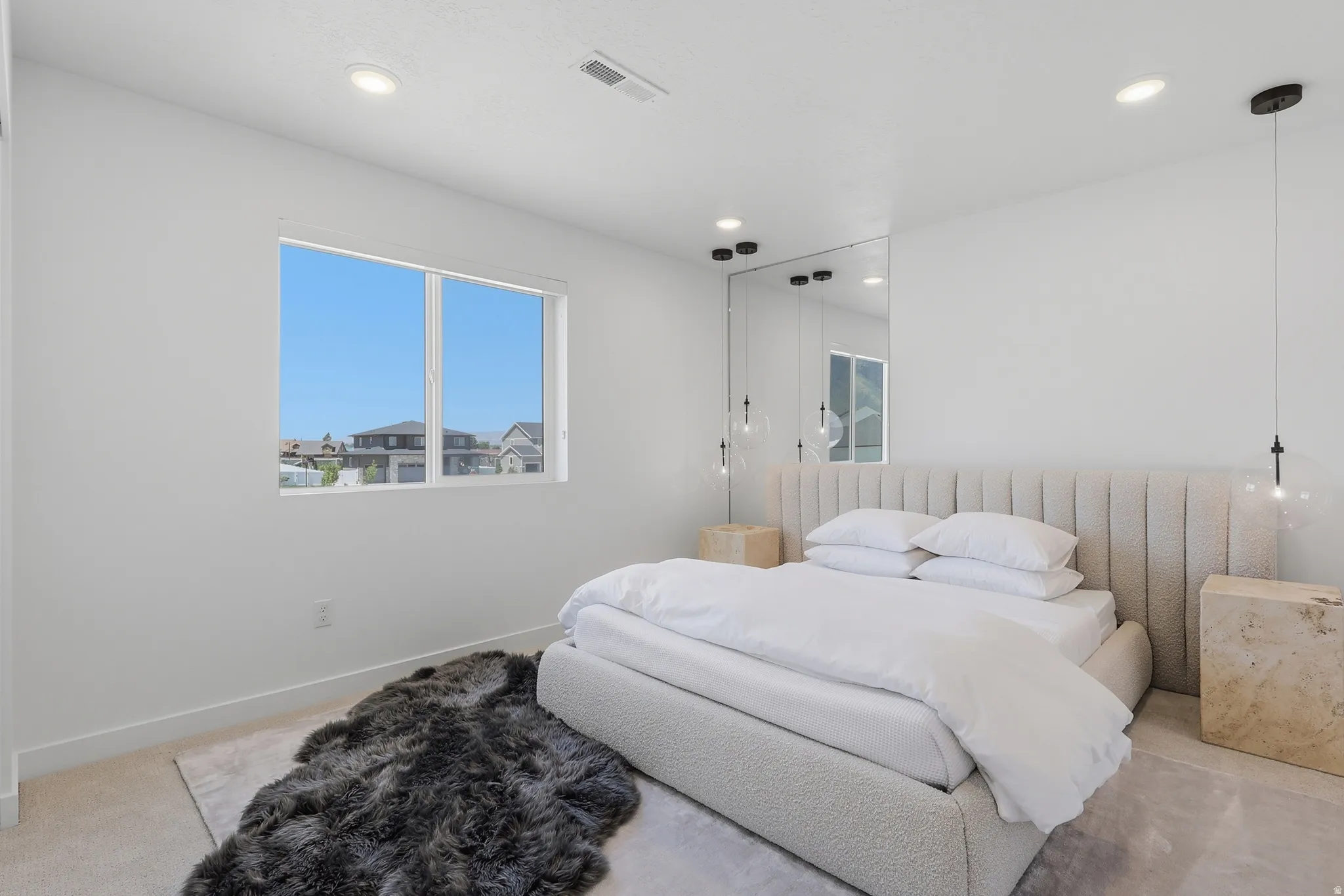Bright room featuring a large window, recessed lighting, and a mirrored accent wall