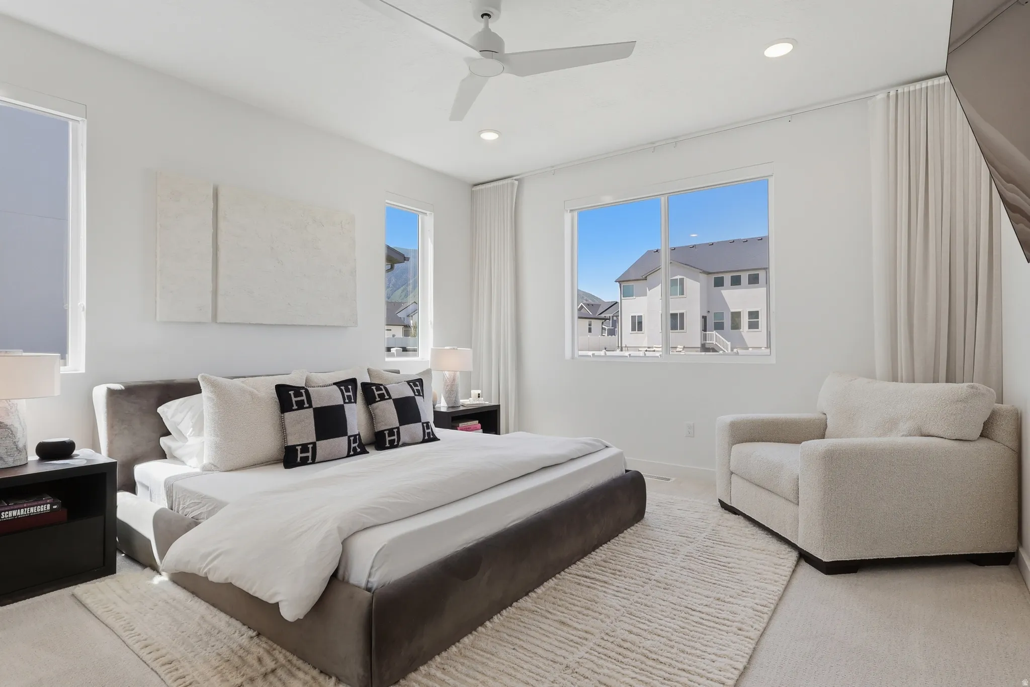 Bright interior space featuring a ceiling fan with integrated lighting, recessed lighting, and multiple windows providing natural light