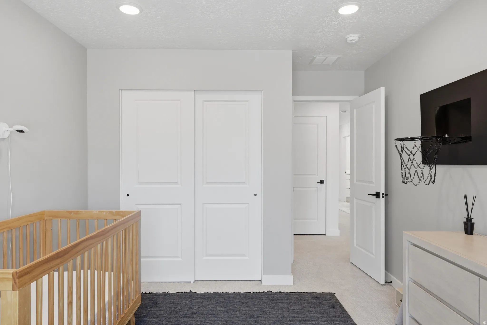 Room with light gray walls, white sliding closet doors, and recessed ceiling lighting