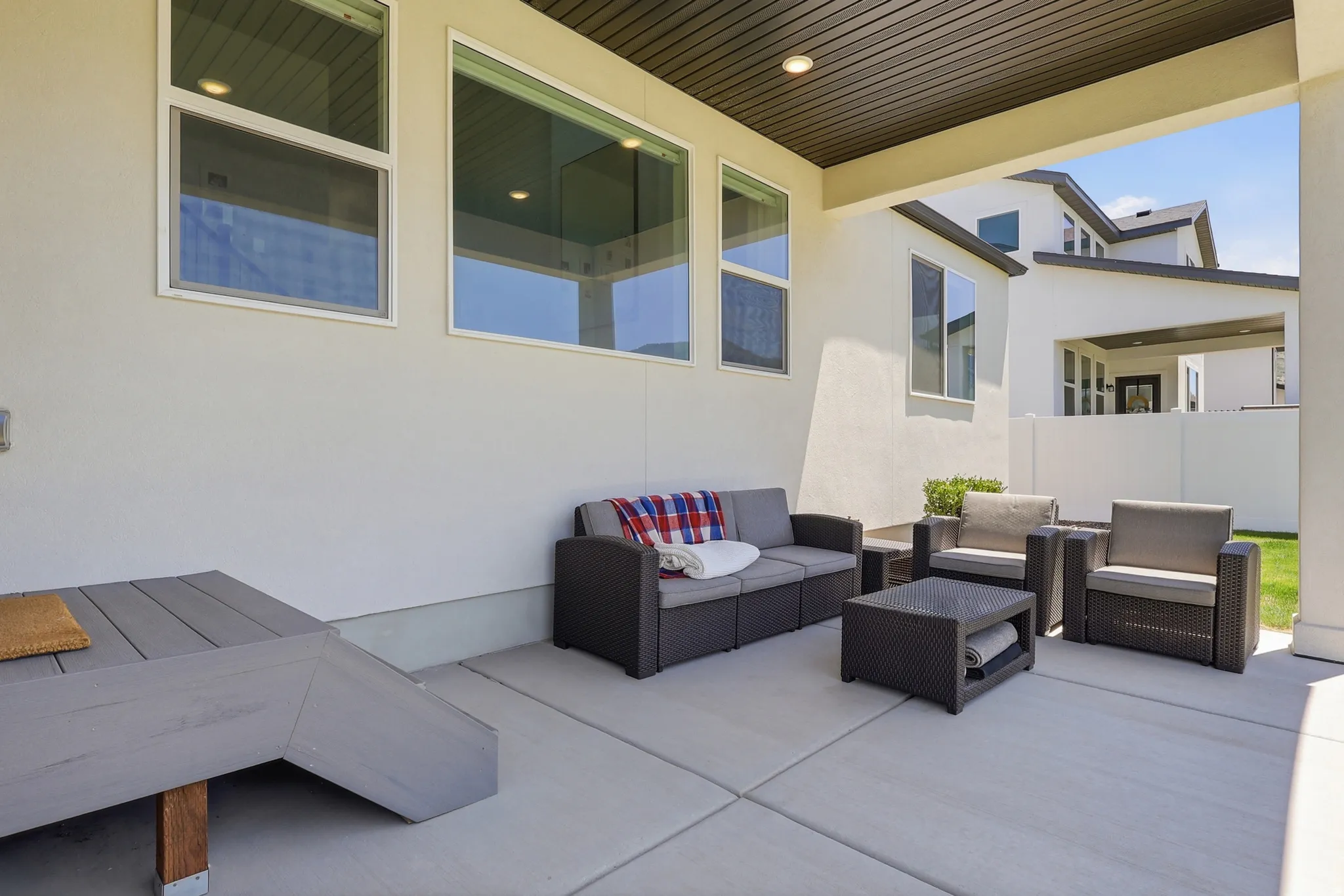 Covered concrete patio featuring recessed lighting, a slatted ceiling, and multiple windows