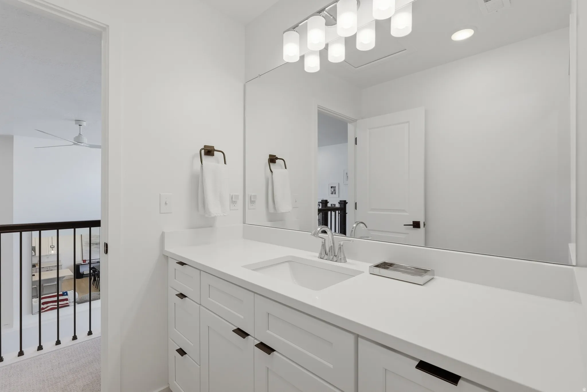 Bathroom vanity featuring a single undermount sink, a chrome faucet, and a light-colored countertop
