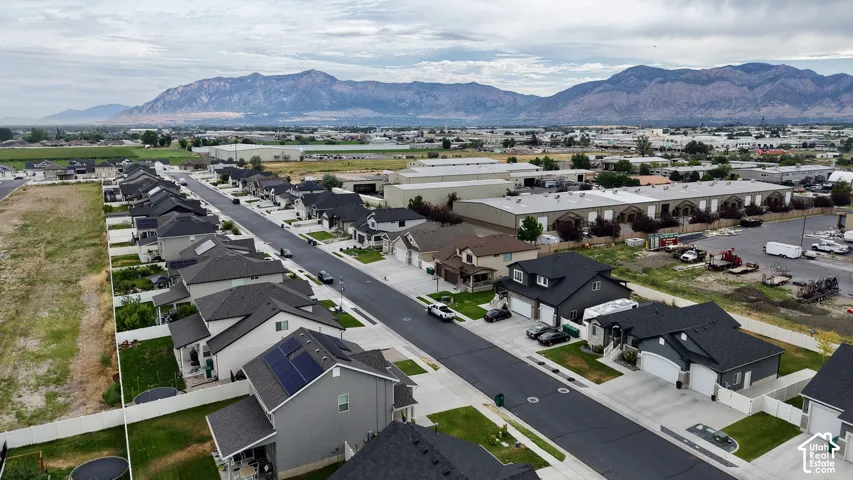 Newly constructed residential street featuring a modern gray home with solar panels