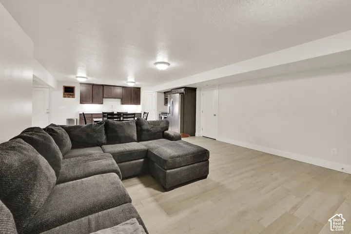Open-concept living area featuring light wood-finish flooring, recessed lighting, and a neutral color palette