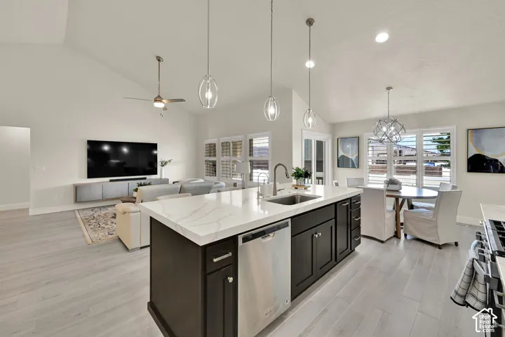 Kitchen island featuring a stainless steel sink, integrated dishwasher, and white countertop