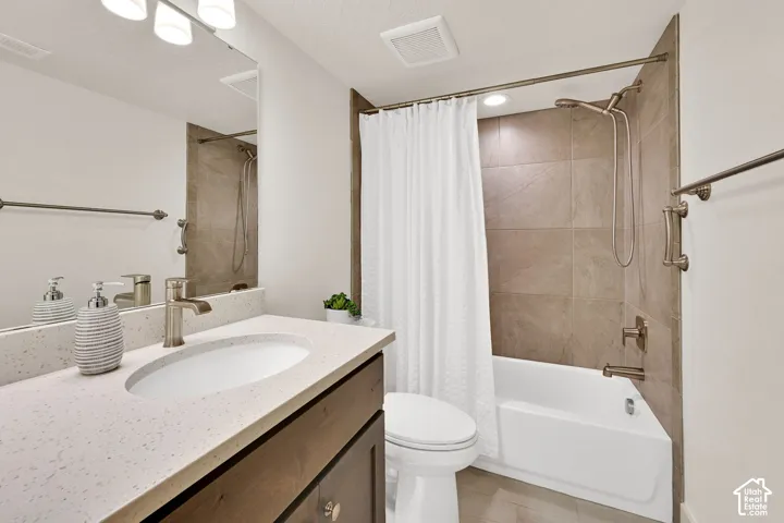 Full bathroom featuring a rectangular drop-in sink with a single-handle faucet, a light speckled countertop, and a dark wood-finish vanity