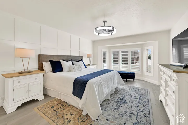 Expansive room featuring wood-finish flooring and a decorative accent wall