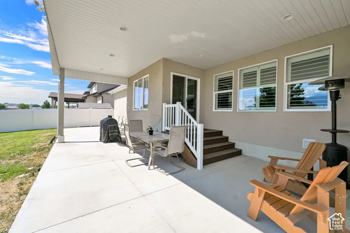 Spacious covered patio featuring recessed lighting, a concrete surface, and direct access to the interior via a sliding glass door and exterior steps