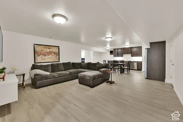 Spacious open-concept living area featuring wood-finish flooring, recessed lighting, and a neutral color palette