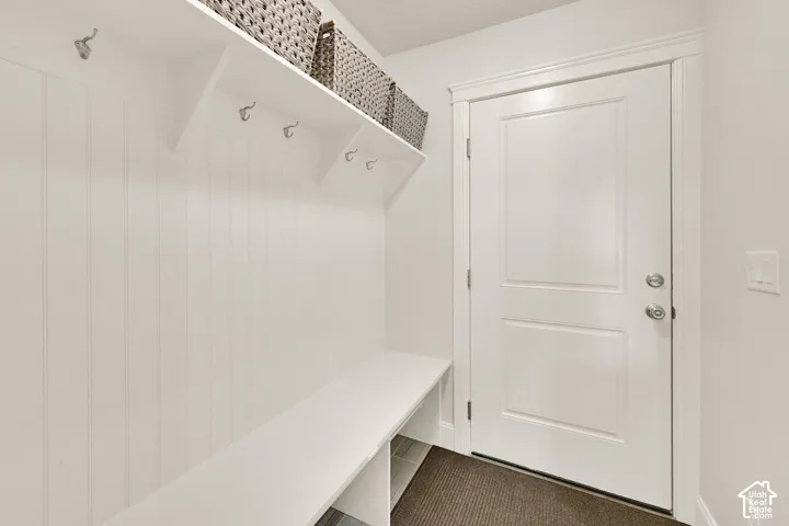 Built-in mudroom bench with beadboard backing, open shelving, and coat hooks