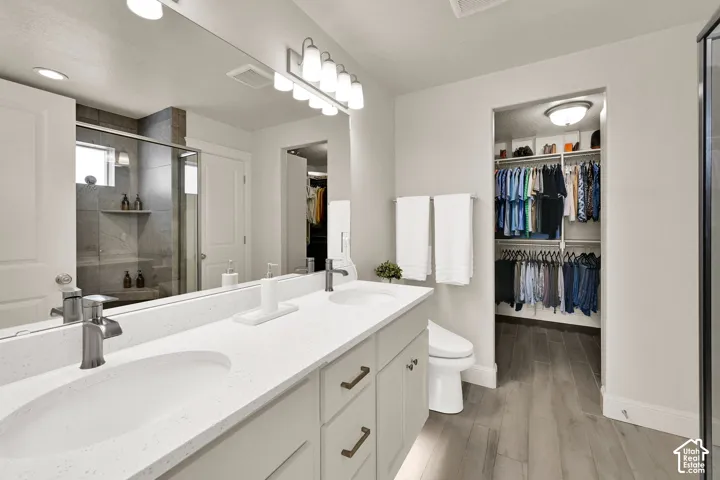 Double vanity with white solid surface countertops and integrated sinks, brushed nickel fixtures, and a six-light vanity bar