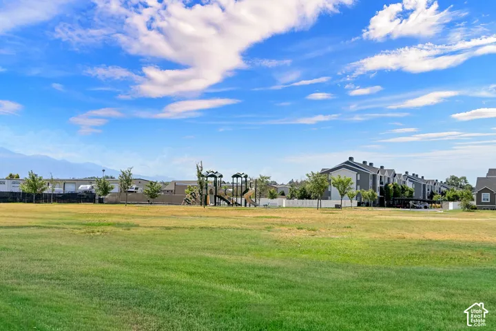 Expansive open green space featuring a playground structure with slides and climbing elements