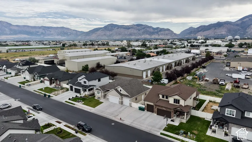 Aerial perspective of a residential street featuring single-family homes with mountain scenery in the background