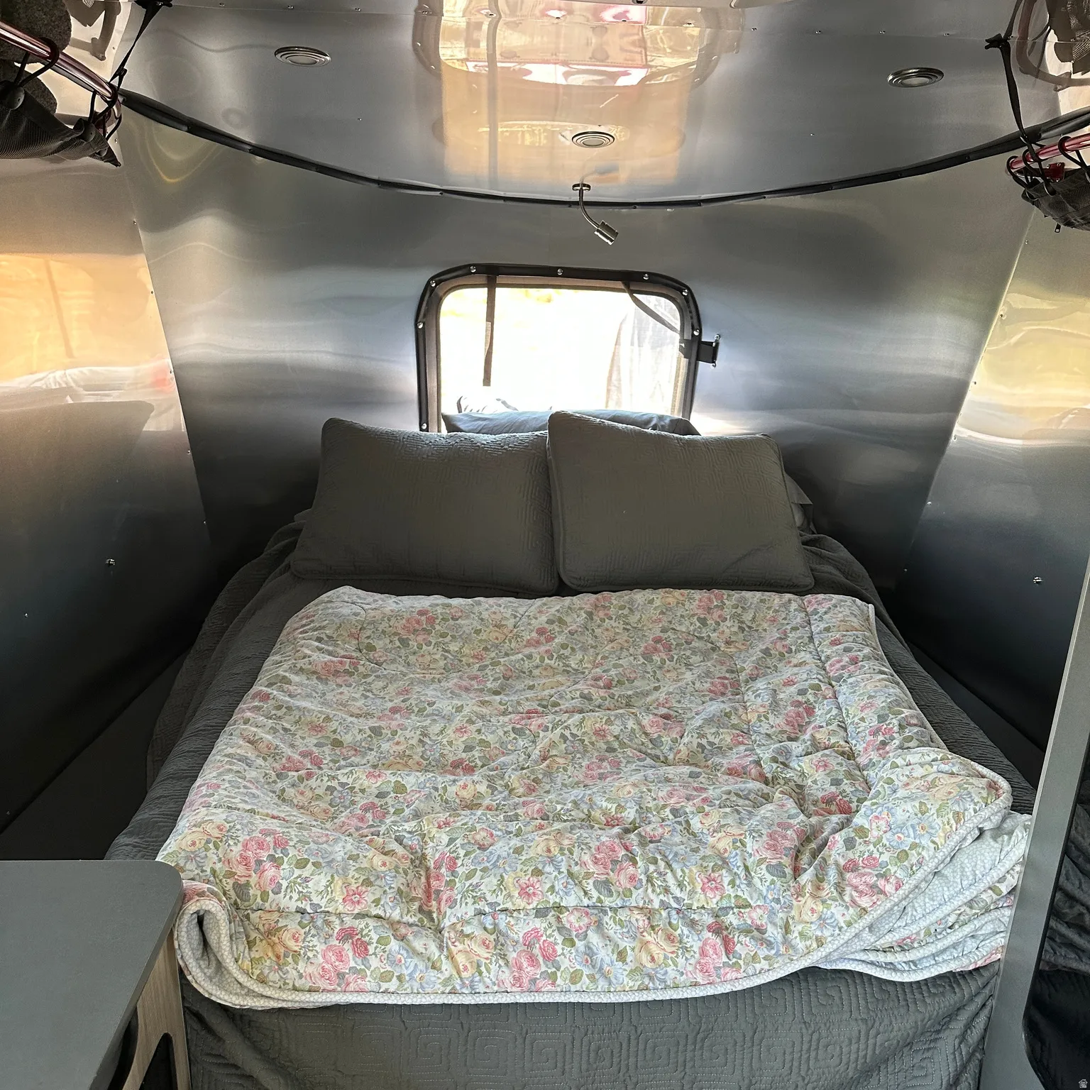Compact sleeping area with a rear window, recessed ceiling lighting, and a flexible reading light