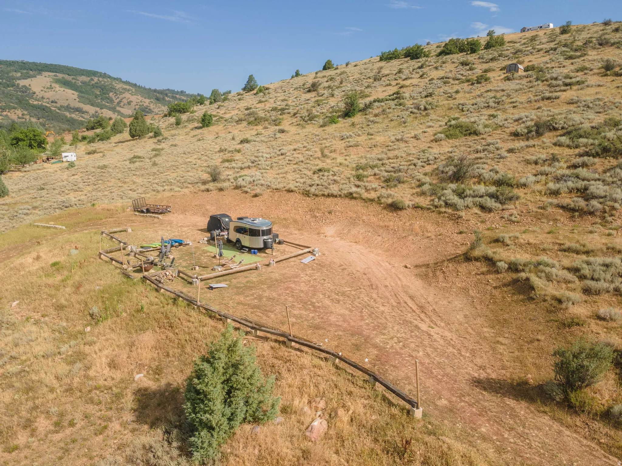 Expansive hillside property featuring a graded level pad, natural terrain, and distant mountain backdrops