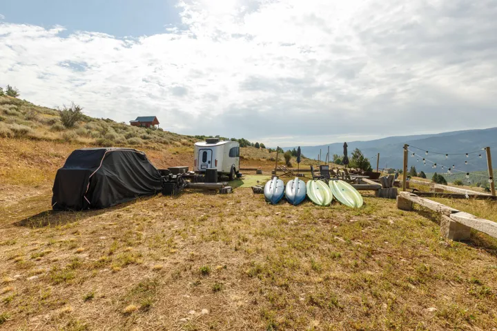 Terraced outdoor area featuring string lights and a distant cabin structure