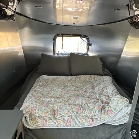 Compact sleeping area with a rear window, recessed ceiling lighting, and a flexible reading light
