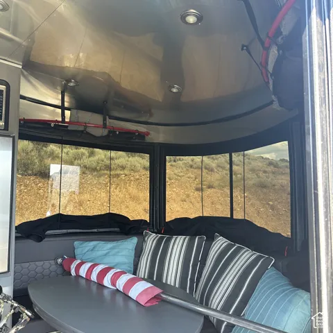 Interior space featuring a curved ceiling with recessed lighting, a built-in bench seating area, and multiple windows