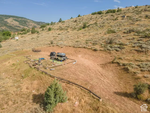Expansive hillside property featuring a graded level pad, natural terrain, and distant mountain backdrops