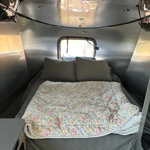 Compact sleeping area with a rear window, recessed ceiling lighting, and a flexible reading light