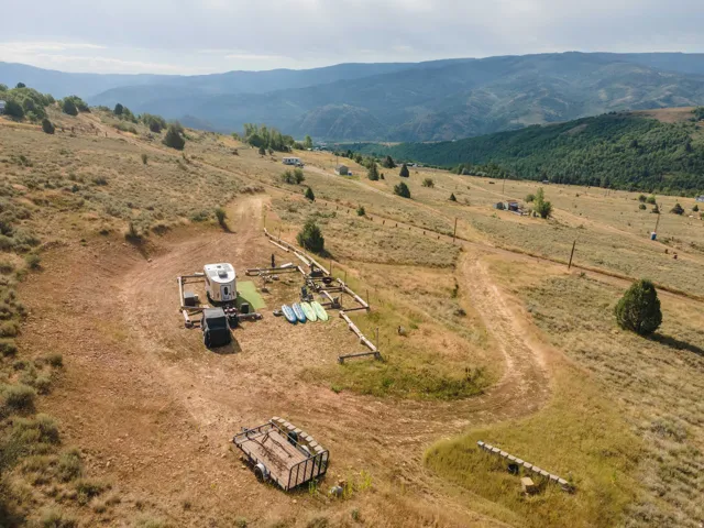 Expansive sloped terrain with natural ground cover and scattered trees