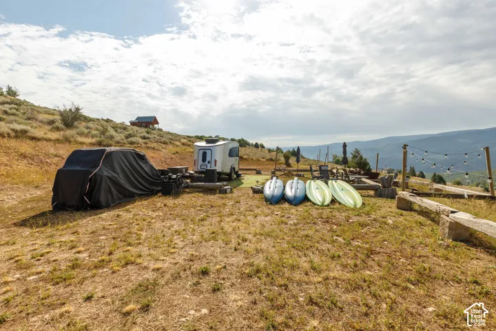 Terraced outdoor area featuring string lights and a distant cabin structure