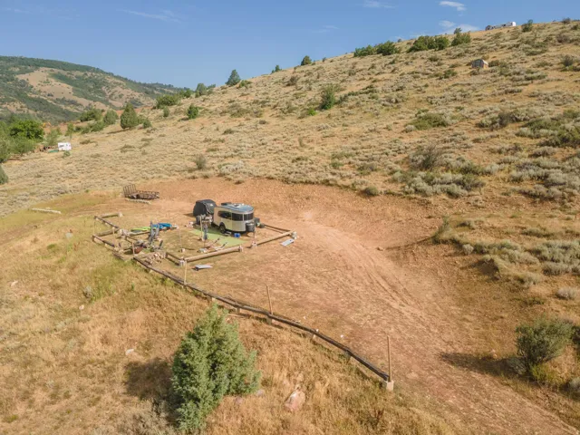 Expansive hillside property featuring a graded level pad, natural terrain, and distant mountain backdrops
