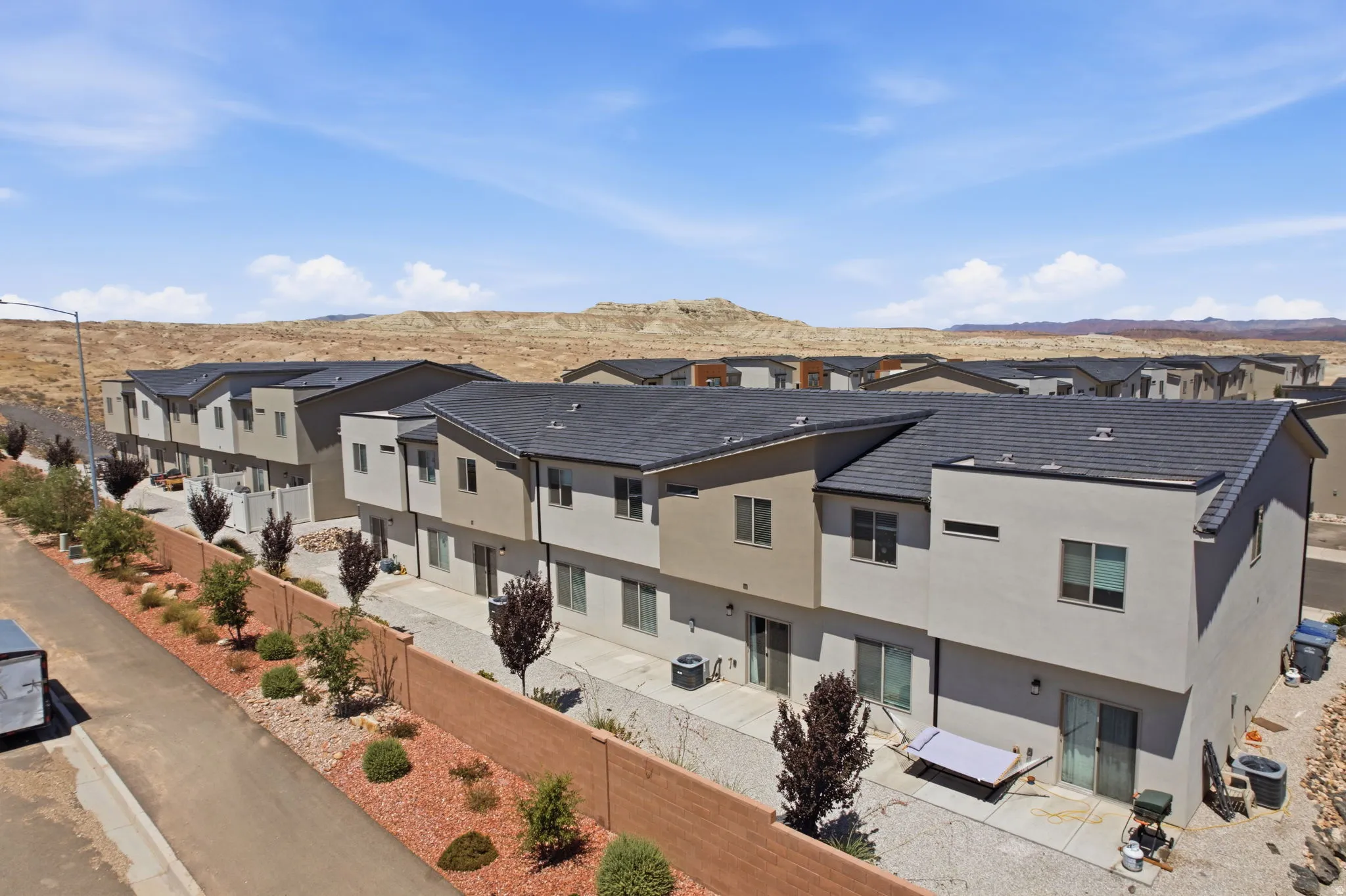 Modern townhomes featuring multi-tone stucco exteriors and dark roofing