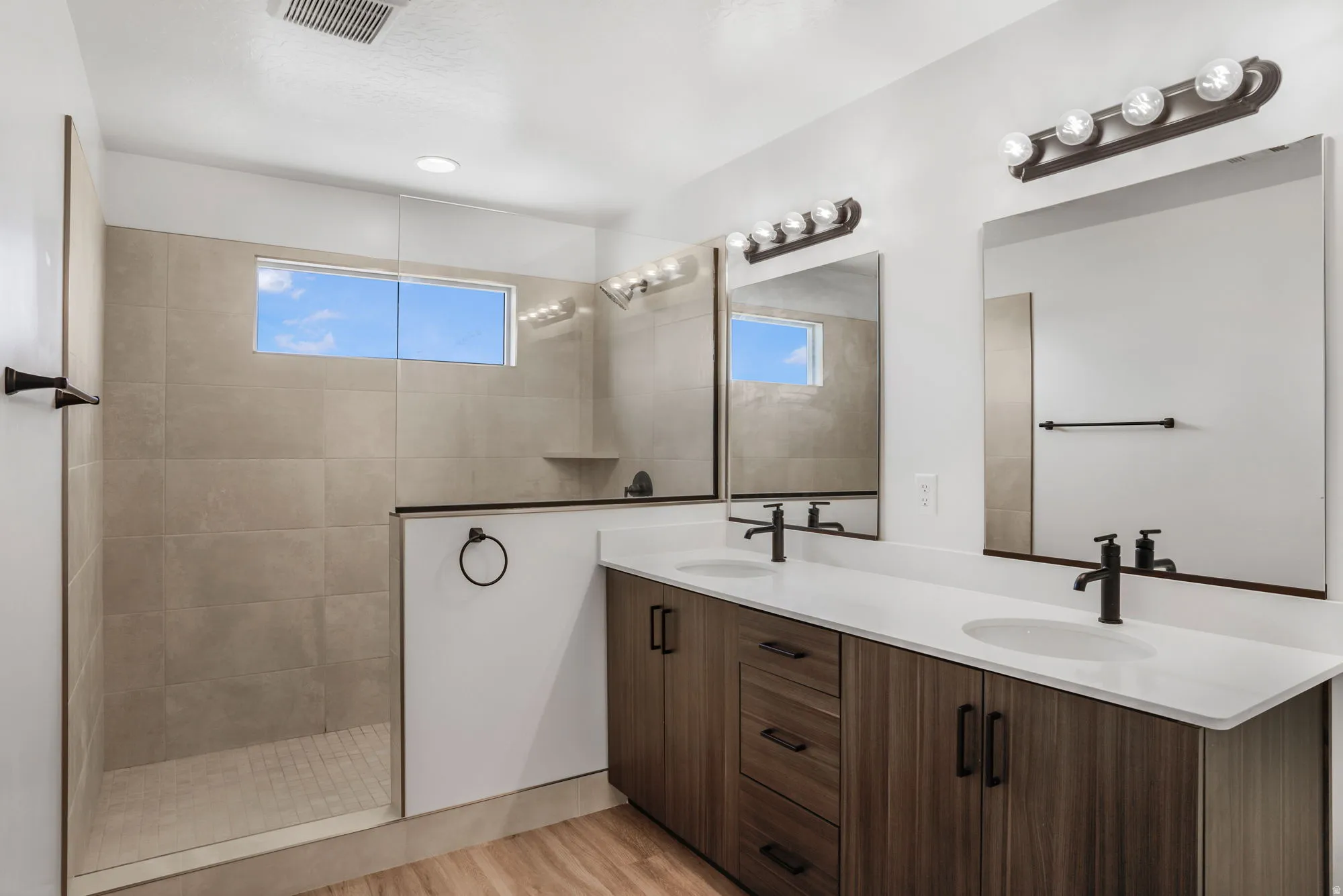 Dual vanity with white countertops, undermount sinks, and matte black fixtures