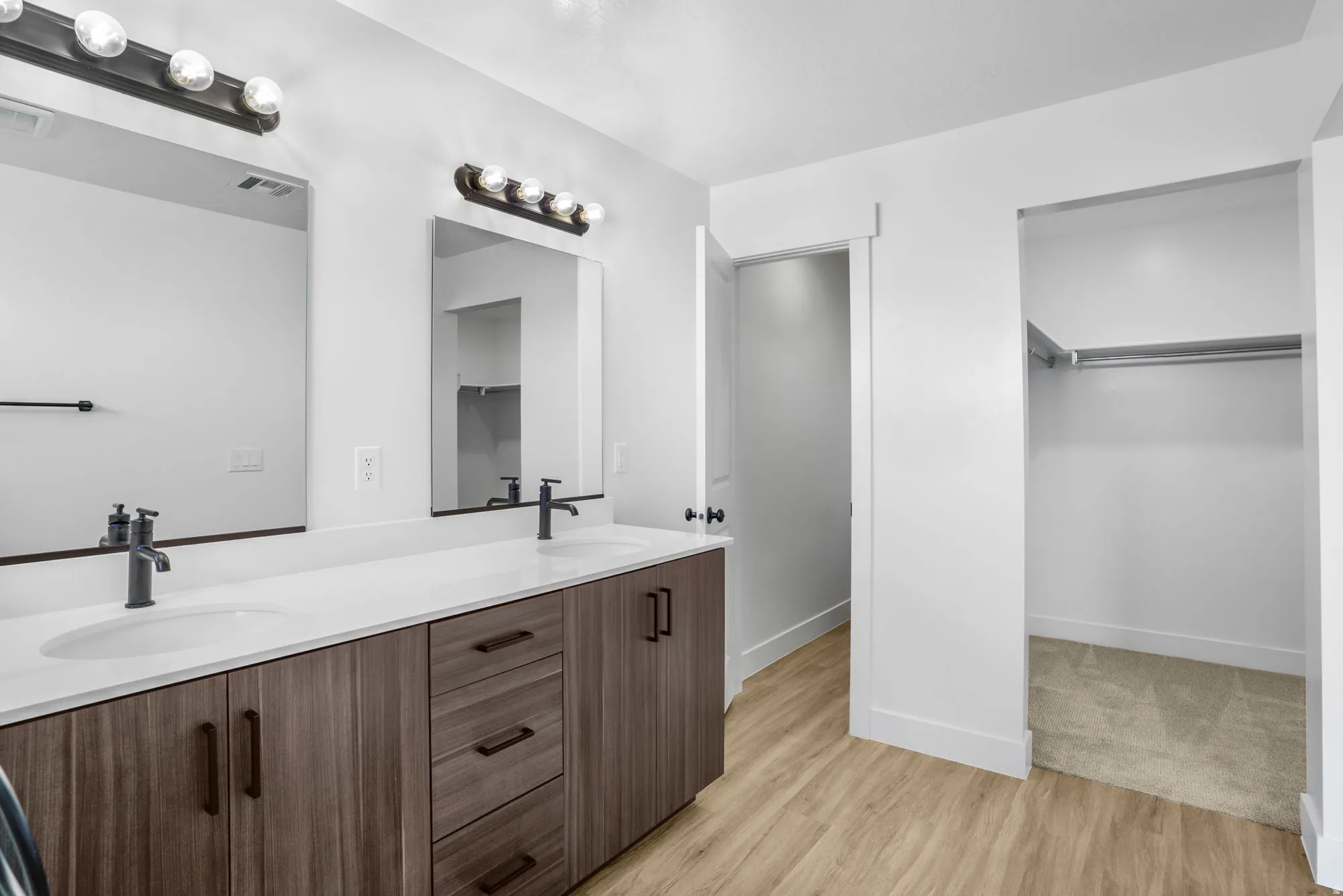 Dual vanity with undermount sinks, quartz-finish countertop, and matte black fixtures