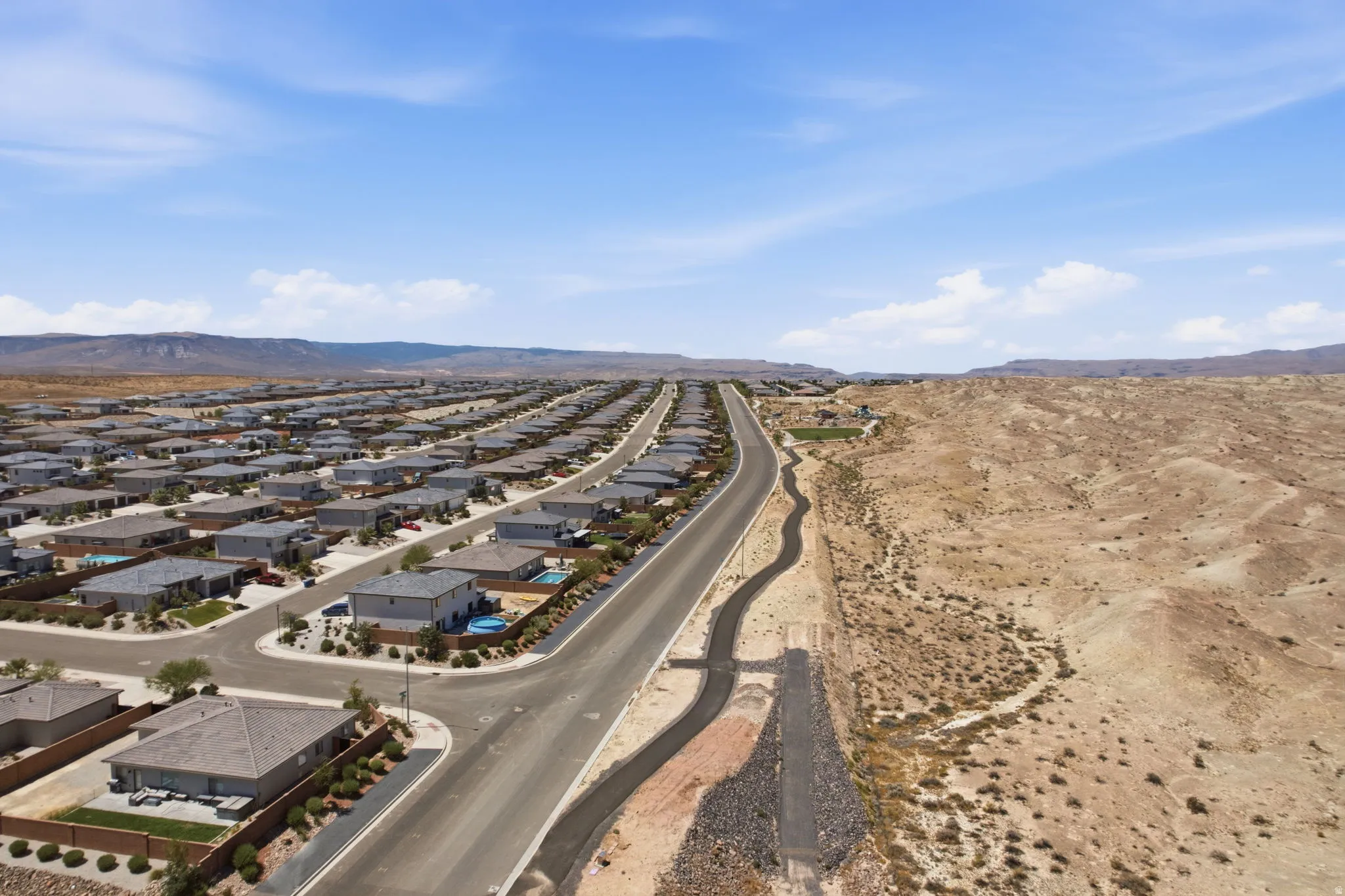 Expansive residential development with numerous single-story homes, paved streets, and desert landscaping