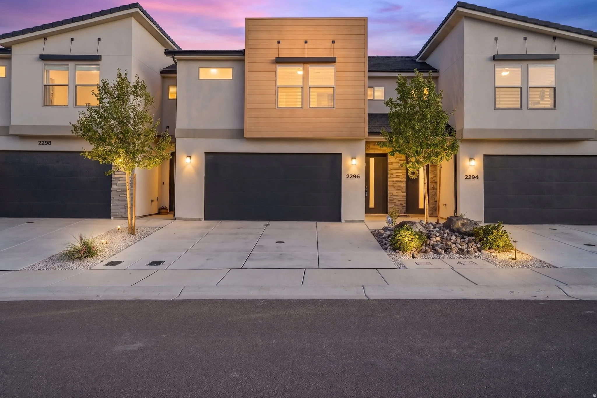 Modern townhome exterior featuring contemporary architectural design and multiple garage bays
