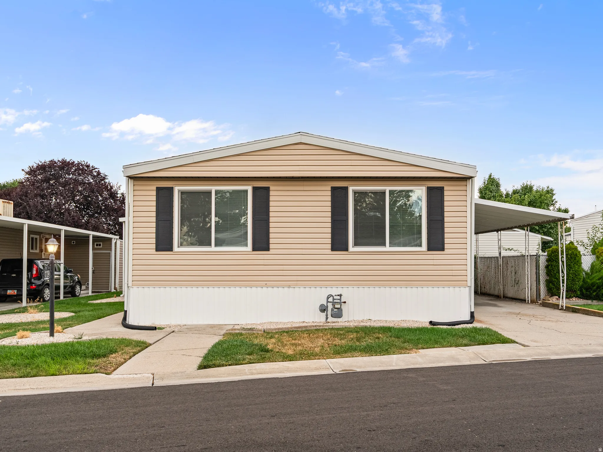 Single-story residence featuring tan horizontal siding and white trim