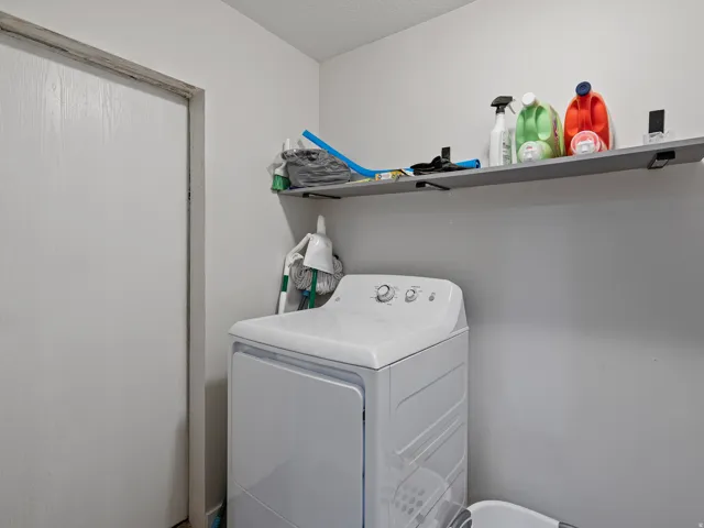 Dedicated laundry area featuring a built-in shelf for storage