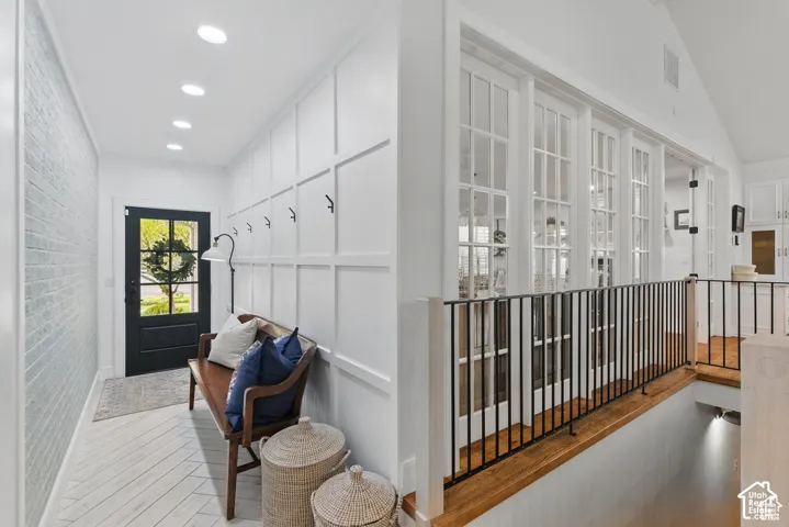 Entryway featuring a black front door with glass panels, white wainscoting, and recessed lighting