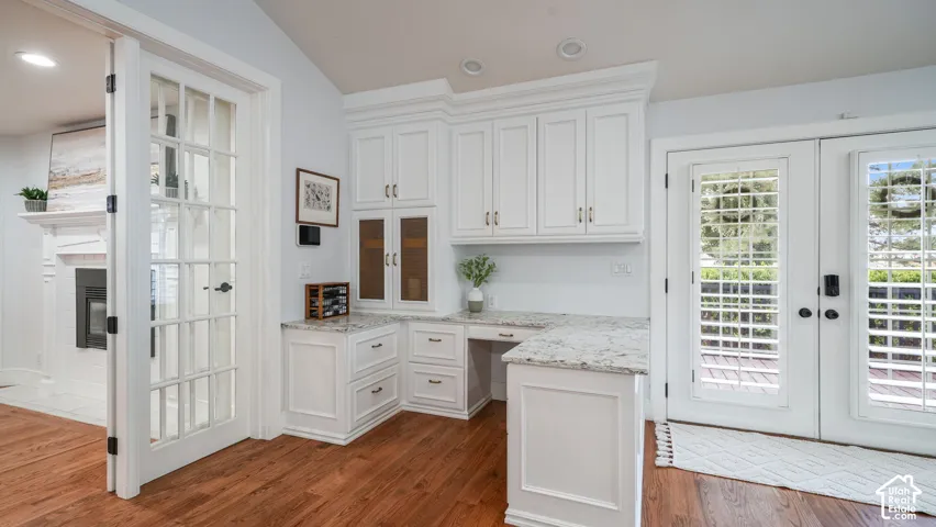 Built-in white cabinetry with a light stone countertop provides dedicated workspace