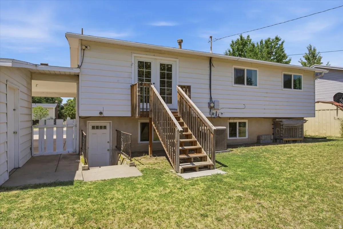 Rear exterior with wood siding and a ground-level concrete patio