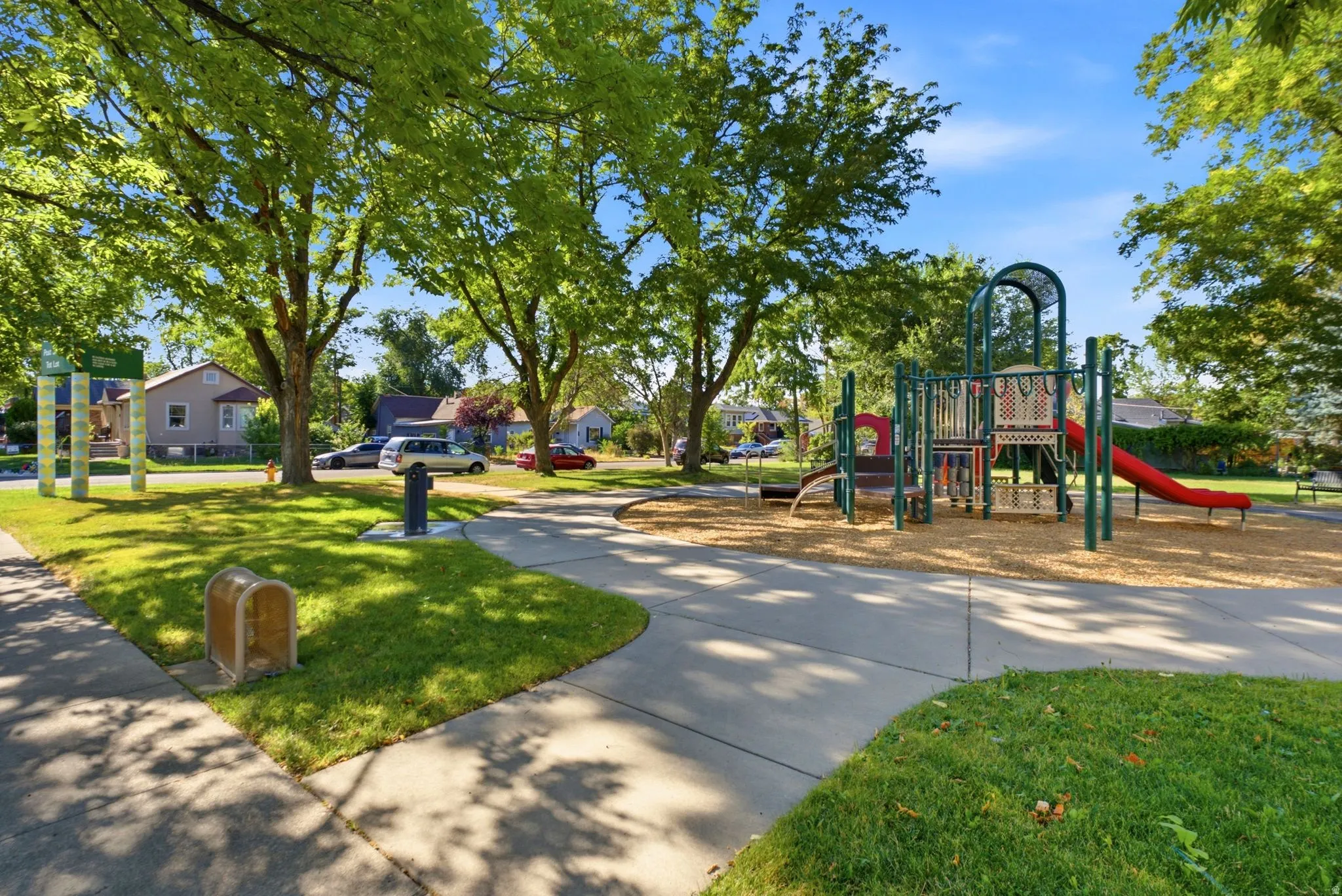 Community playground featuring multiple slides and climbing structures on a wood chip base