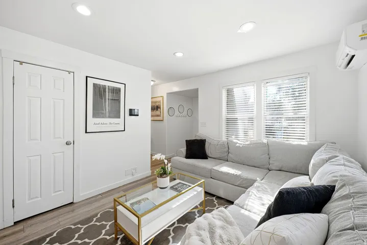 Open concept living space featuring recessed lighting and wood-finish flooring