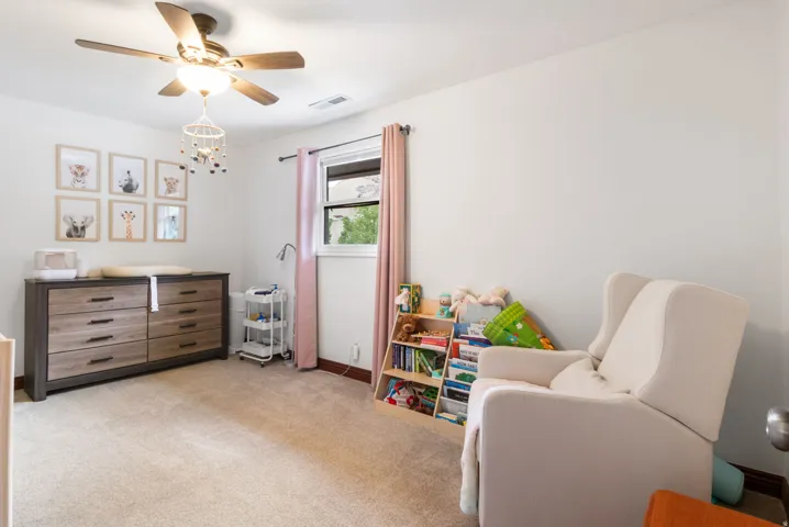 Room featuring a ceiling fan, carpet flooring, a window with trim, and white wall finishes