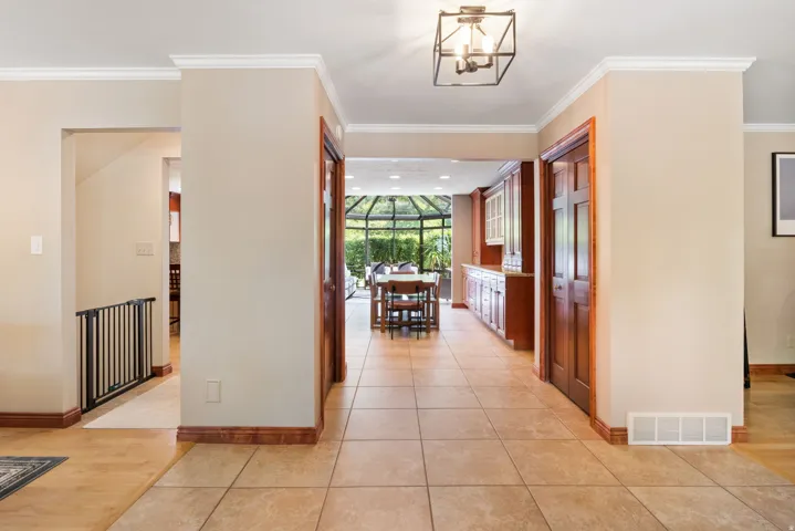 Tiled flooring throughout the main hallway leading to a sunroom with a dining area