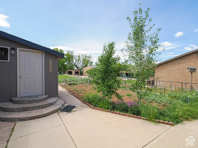 Detached structure with panel siding, a single entry door, and a exterior light fixture