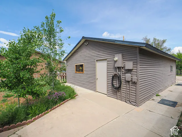 Detached structure with horizontal siding, a single entry door, and a small window featuring a wooden frame