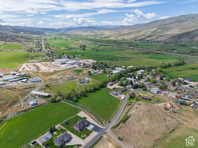 Expansive valley setting featuring mature green fields and distant mountain ranges