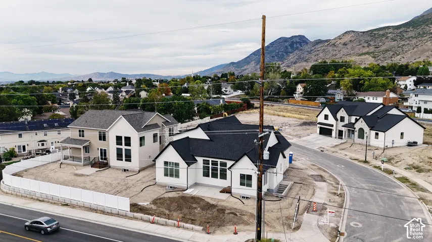 New construction homes featuring contemporary exteriors with dark roofs, attached garages, and a paved street
